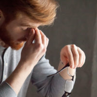 man rubbing bridge of nose